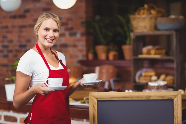 Mooie serveerster houden twee kopjes koffie — Stockfoto