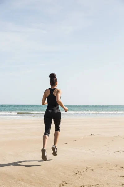 Fit vrouw joggen op het zand — Stockfoto