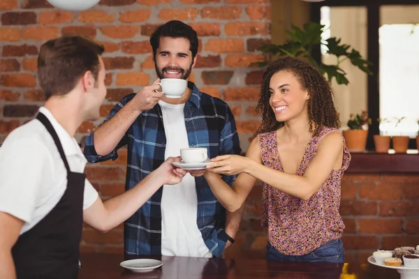 Des clients souriants reçoivent une tasse de café — Photo