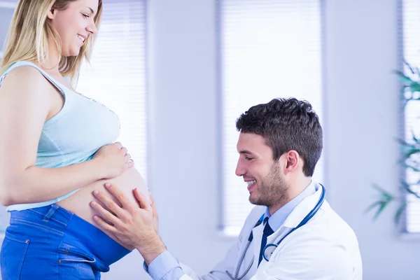 Doctor checking stomach of pregnant patient — Stock Photo, Image