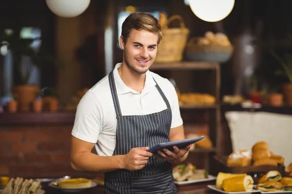 Yakışıklı garson bir tablet holding — Stok fotoğraf