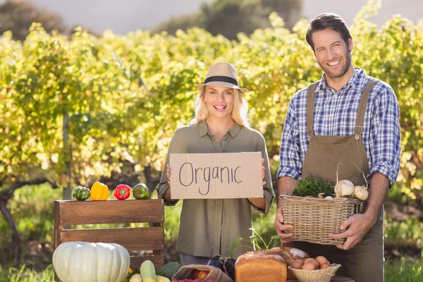 Couple agriculteur tenant un panier et signe biologique — Photo