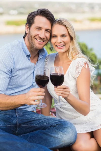 Linda pareja en la fecha celebración de copas de vino tinto —  Fotos de Stock