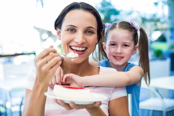 Mother eating a piece of cake with her daughter — Stock Photo, Image