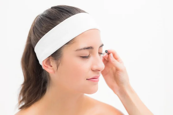 Hand applying mascara to woman — Stock Photo, Image