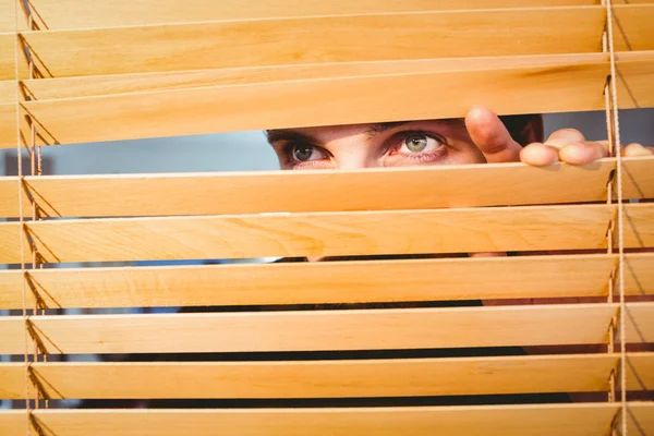 Hipster businessman peeking through blinds — Stok fotoğraf