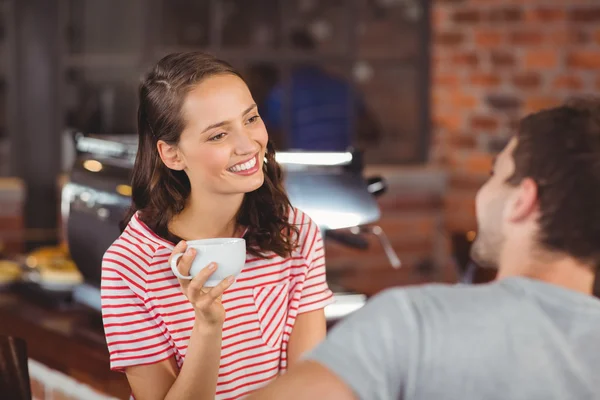 Sorridente giovane donna godendo il caffè con un amico — Foto Stock