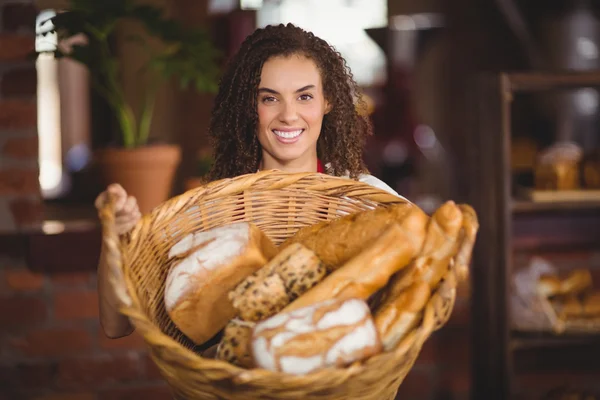 Smiling waitress showing a basket of bread — Stock Photo, Image