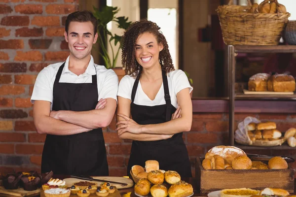 Usmívající se číšník a servírka s rukama přes — Stock fotografie