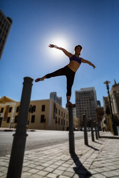 Athletic woman balancing on bollard — Stock Photo, Image