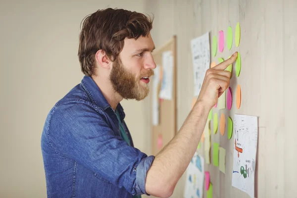 Skäggiga hipster tittar på brainstorm vägg — Stockfoto