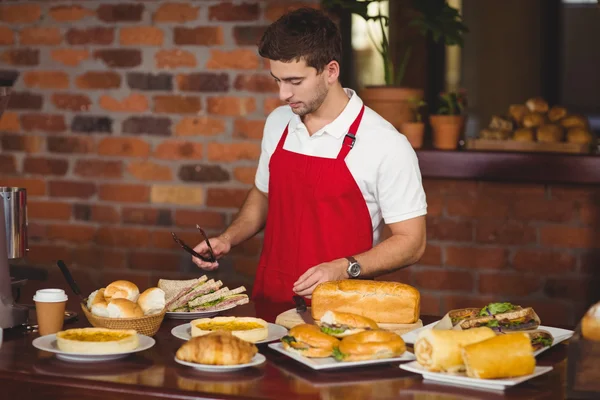 Handsome waiter about to pick a roll — Stock Photo, Image