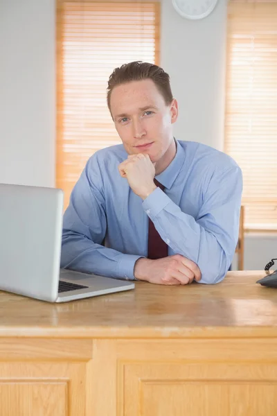 Zufriedener Geschäftsmann sitzt an seinem Schreibtisch — Stockfoto