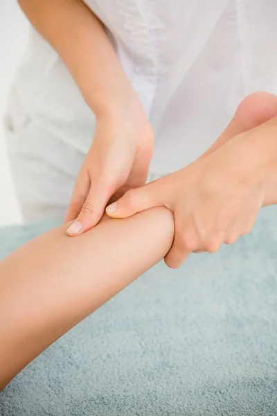 Massagista massageando a perna da mulher — Fotografia de Stock