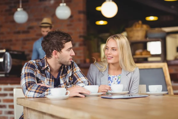 Zwei lächelnde Freunde, die miteinander reden und Kaffee trinken — Stockfoto
