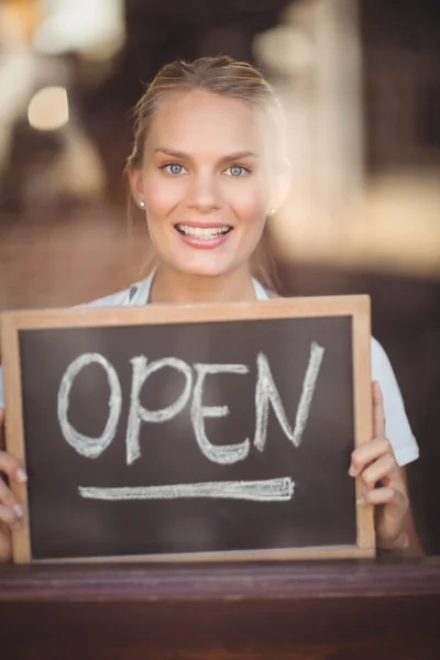 Cameriera bionda sorridente che mostra lavagna con segno aperto — Foto Stock