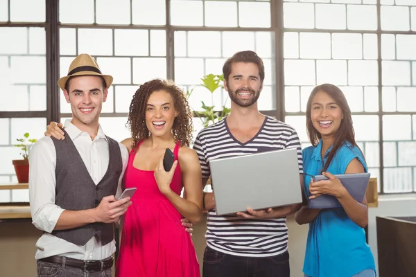 Amigos sonrientes sosteniendo diferentes tipos de multimedia —  Fotos de Stock