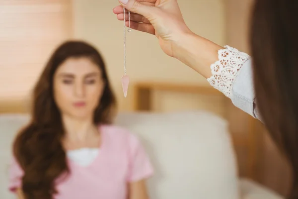 Hypnotherapist holding pendulum before hr patient — Stock Photo, Image