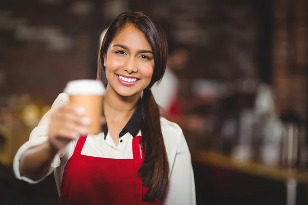 Lächelnde Kellnerin reicht einen Becher zum Mitnehmen — Stockfoto