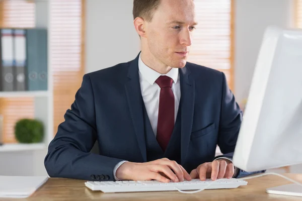 Uomo d'affari concentrato che lavora alla sua scrivania — Foto Stock