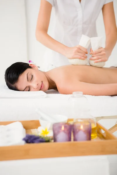 Woman enjoying herbal compress massage — Stock Photo, Image