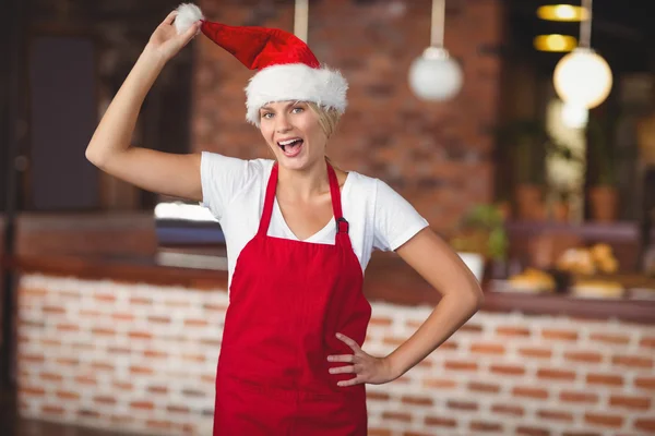 Pretty waitress touching her santa hat — Stock Photo, Image