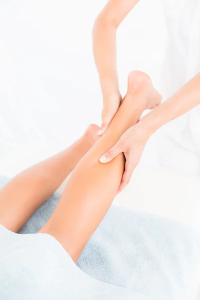 Massaggiatore femminile massaggiando la gamba della donna — Foto Stock