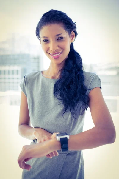 Femme d'affaires souriante utilisant sa smartwatch — Photo