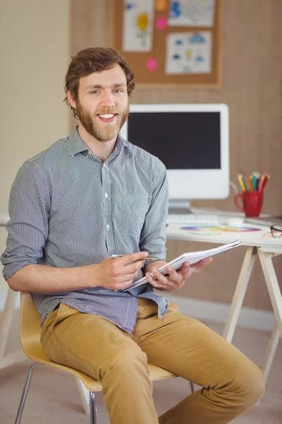 Hipster barbu souriant à la caméra tenant des notes — Photo