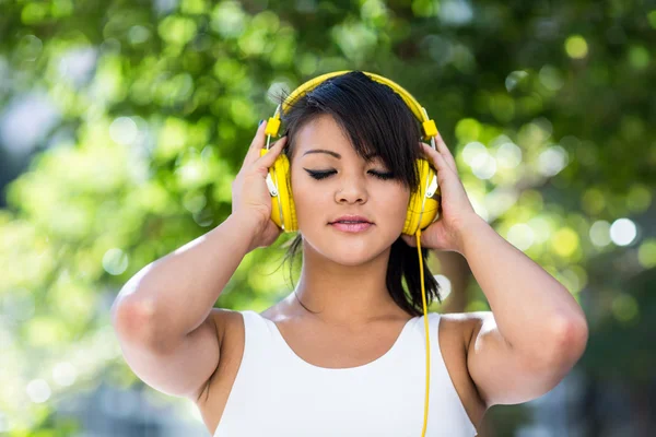 Kobieta nosi żółty słuchawki — Zdjęcie stockowe
