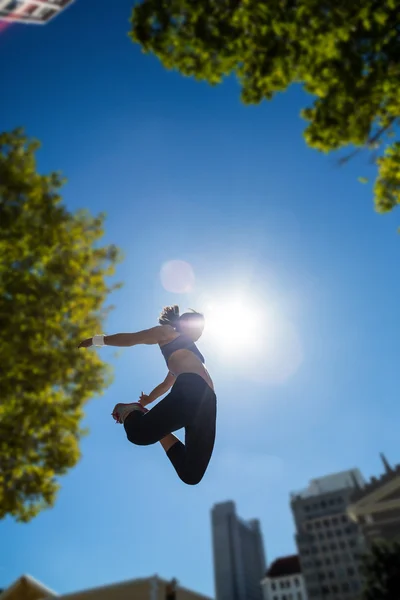 Спортивная женщина, прыгающая в воздух — стоковое фото