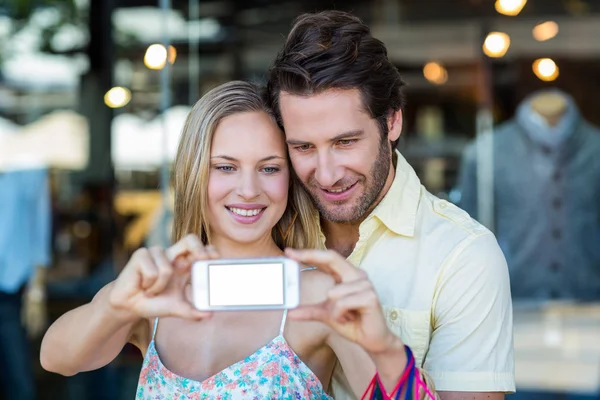 Paar mit Einkaufstüten macht Selfies — Stockfoto