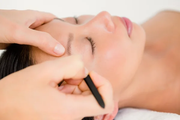 Woman using tweezers on patient eyebrow — Stock Photo, Image