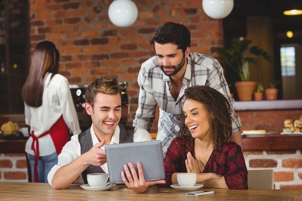 Smiling friends looking at digital tablet — Stock Photo, Image