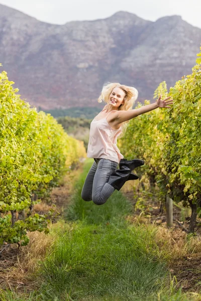 Blonde winegrower jumping in a vineyard — Stock Photo, Image