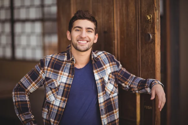 Sorrindo garçom casual encostado à porta — Fotografia de Stock