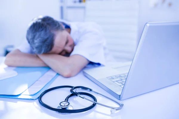 Médecin féminin dormant sur le bureau — Photo