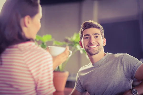 Sonriente joven tomando café con su amigo — Foto de Stock