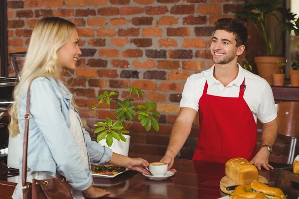 Uśmiechnięty barista serwuje klienta — Zdjęcie stockowe