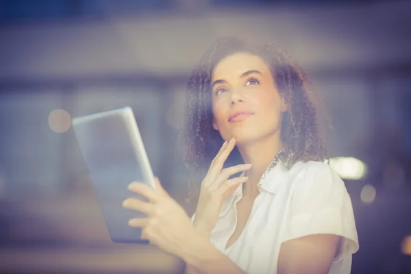 Eftertänksam kvinna med hjälp av en digital tablet — Stockfoto