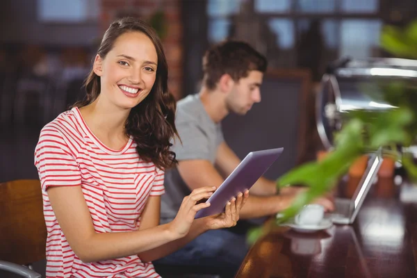 Усміхнена молода жінка використовує планшетний комп'ютер — стокове фото