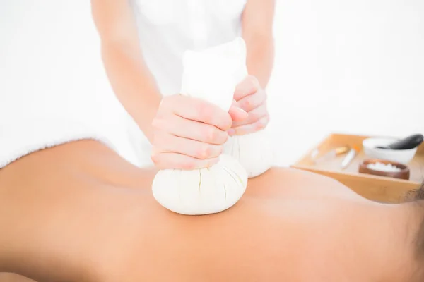 Brunett njuter växtbaserade compress massage — Stockfoto