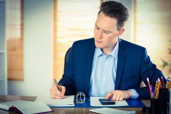 Hombre de negocios concentrado anotando — Foto de Stock