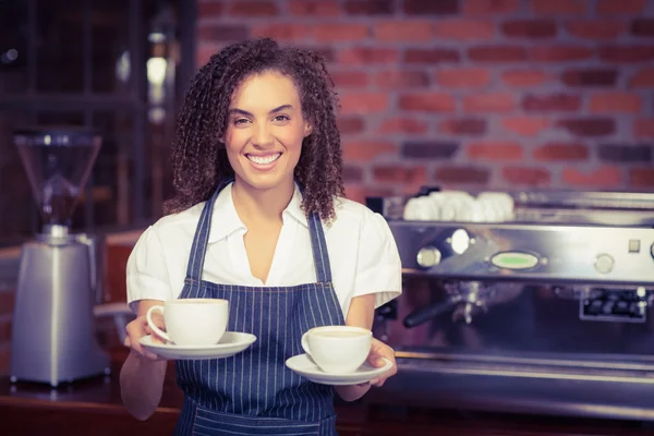 Barista sonriente sosteniendo dos tazas de café —  Fotos de Stock