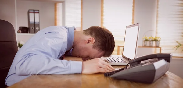 Uomo d'affari stressato con testa sul computer portatile — Foto Stock