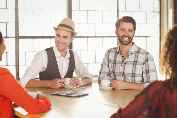 Riendo amigos tomando café juntos — Foto de Stock