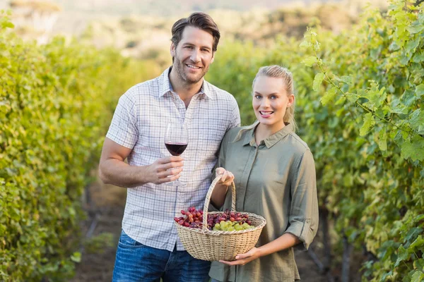 Two young happy vintners holding a basket — Stock Photo, Image