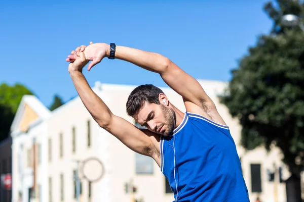 En stilig idrottsman stretching — Stockfoto