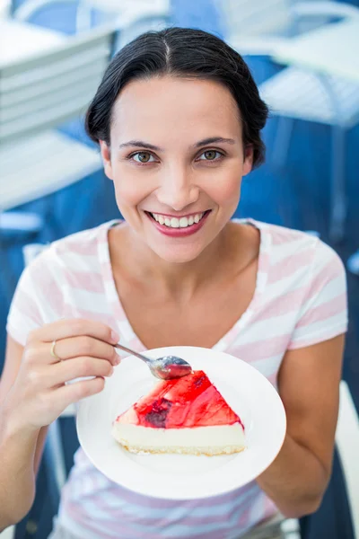 Morena sorridente tomando um pedaço de bolo de chocolate — Fotografia de Stock