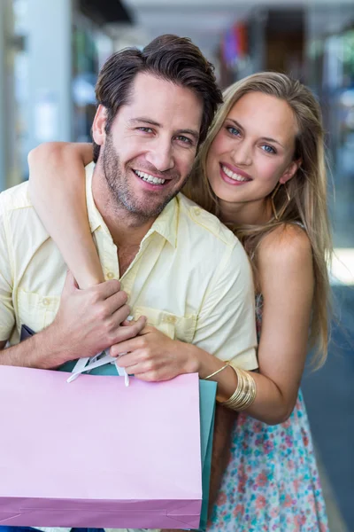 Casal com sacos de compras abraçando — Fotografia de Stock